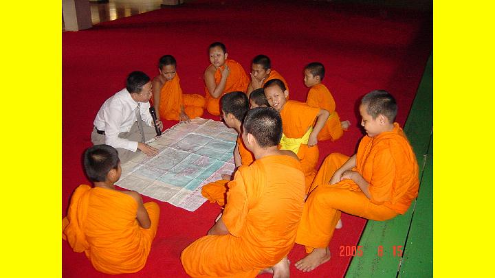 020UFchart.jpg - A Thai teacher of Maharishi?s Transcendental Meditation Programme shows a Unified Field chart to young Buddhist monk students. The young students were very interested in Maharishi?s knowledge, and thrilled to see this chart illustrating how the Unified Field of Natural Law, described by modern quantum physics, is experienced directly as the field of pure consciousness, the Self, during the practice of Transcendental Meditation.