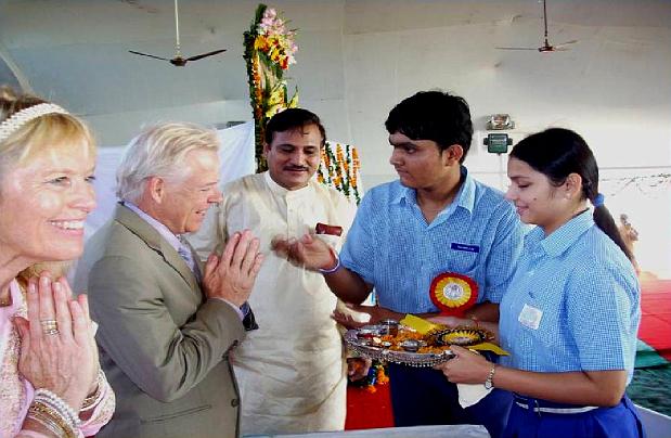 60.jpg - Dr Alarik and Cynthia Arenander receive the traditional, respectful greeting of a tilak on the forehead from Maharishi Centre for Educational Excellence students at the Maharishi Vidya Mandir National Cultural Meet. Dr T C Pathak, Director of Communications and Public Relations for Maharishi Centre for Educational Excellence, looks on.