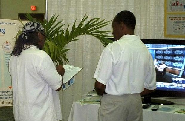 8.jpg - 10 September 2009 An interested participant signs up for the Introductory lecture on Transcendental Meditation. On the screen is a presentation of brain wave coherence showed the development of total brain functioning.