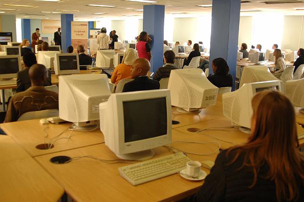 16.jpg - Students sit in front of their computer monitors while listening to Dr Taddy Blecher. Dr Blecher created the first free university in South Africa and is eliminating poverty through a new institute and programme of educating Africa?s youth.