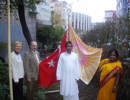 008--AT-teachers.jpg - Dr Baruh and his wife, and Vedic Experts from India, raising the Flag of Invincibility on Victory Day.