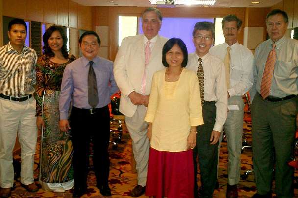 VN-(18).jpg - In Ho Chi Minh City, Vietnam, Dr Morris, (centre in white) along with Dr Dennis Heaton, (far right) Dean of Distance Education for Maharishi University of Management (MUM), held a meeting to discuss the future of Maharishi's programmes within the nation. Attending this meeting were the director of the international organization which has been sponsoring Transcendental Meditation Teachers in Vietnam; a practitioner of the technique who has a strong desire to become a Teacher; in yellow is Dr Eileen Fo, a leader of the Global Country of World Peace in Malaysia; and Charles Tran, to the right of Dr Fo, who left Vietnam in 1975 and received a degree from MUM.