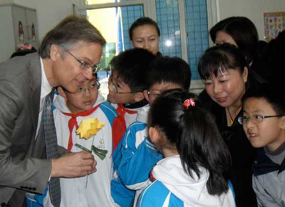 25Chinastudents.jpg - Dr Beall answers questions and receives flower art projects from students.