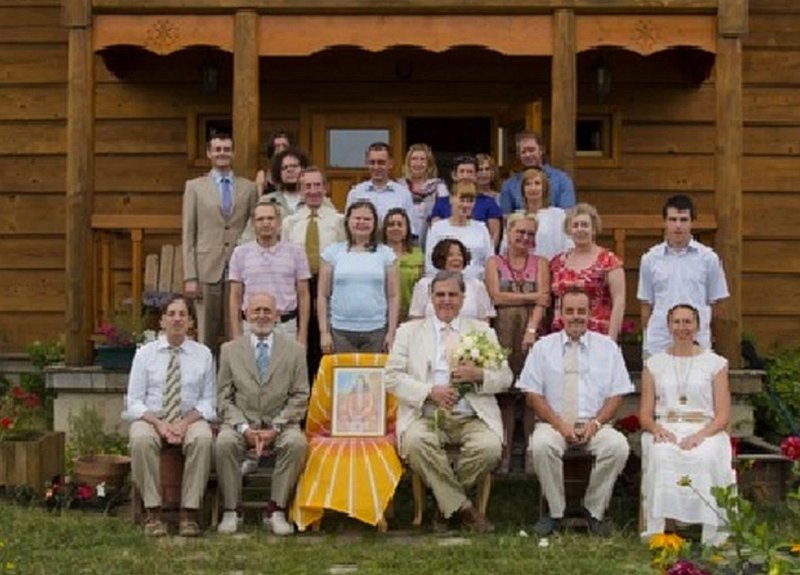 23-Poland.jpg - Dr Bevan Morris, seated in front of a Polish Vastu home (with flowers), met with local practitioners of Transcendental Meditation to hear their successes in promoting Maharishi?s Invincible Defence Technology.