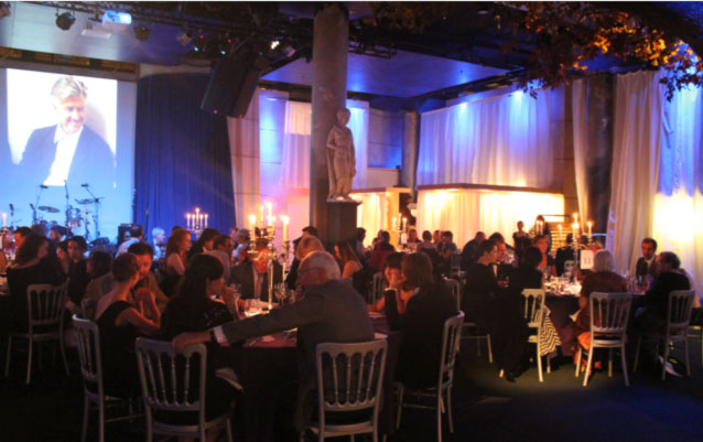 14-DLF.jpg - Distinguished guests from different fields? film, fashion, art, music, media, and drama? attended the banquet. Mr David Lynch, seen on the screen in the top left, addressed the group through a videoconference link.