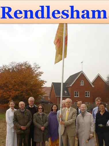 UKRendlesham.jpg - United Kingdom: Residents of the village of Rendlesham, who greatly enjoy their homes built according to principles of Maharishi Vedic Architecture, raise the Flag of Invincibility. From left: Jane Strachey, Ian Park, John Darby, Varerie Darby, Jeanie Livesley, Nigel Kahn, , Richard Johnson, the National Director for England, is holding the flag, Paul Kember, Jutith Kember, Anthony Hardy, the National Director for Trade and Commerce, Nina Robinson.