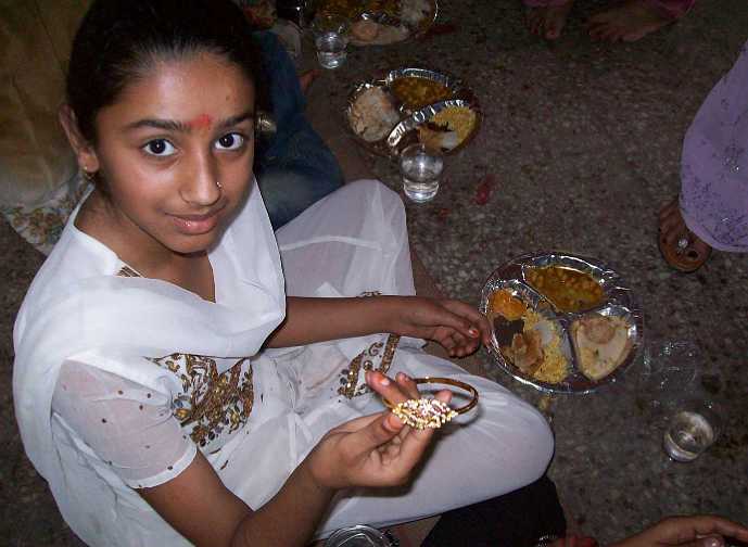 02_India_05.jpg - Banquets for young people were held in the spring on Navami (the Ninth day) of the Navaratri festival. One hundred girls attended this traditional Vedic celebration, which included the giving of gifts; here they receive bracelets and special round stainless steel lunch boxes called tiffins.