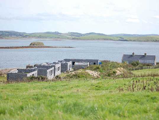 15-Buildings-from-hill.jpg - Dr Morris' visit to the Maharishi Island of world Peace resulted in tremendous new support for construction of the course facilities. Facilities are to include 42 single rooms, as well as lecture halls, dining halls, and kitchens to accommodate guests.