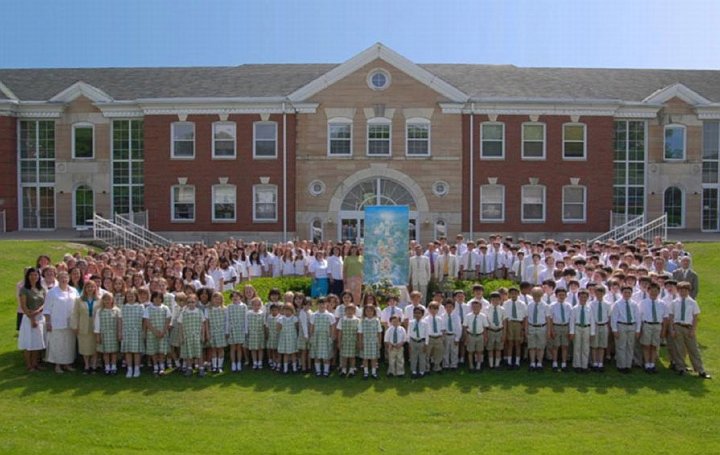 11_Bevan.jpg - Maharishi School of the Age of Enlightenment (MSAE) student body and faculty are seen in front of the school building. The text above the front door of the school says, ?In their awareness will shine the world?s most precious wisdom.? And you can see it in the faces of the children.