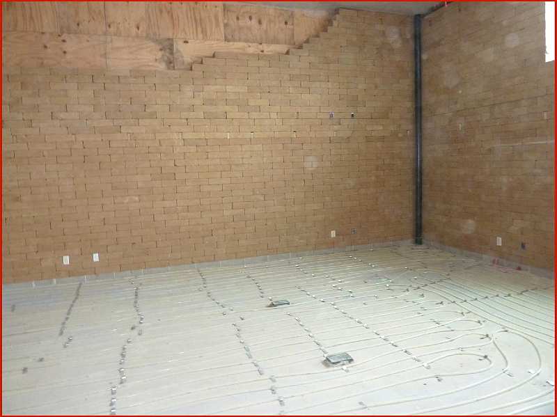 Slide28.jpg - Main classroom facing west showing in-floor radiant heating being installed, and compact earth blocks in the wall.