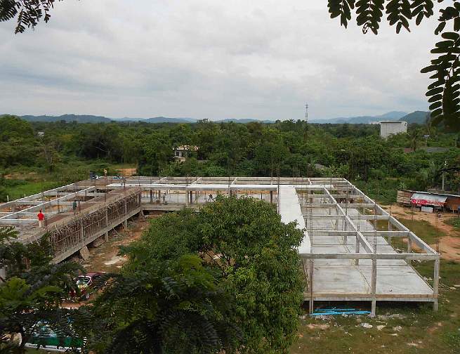 S13,-Yala-school.jpg - Rajapark Institute, an institution of higher learning offering Consciousness-Based Education in Thailand, has acquired land in the capital of Yala Province in southern Thailand to build another Vastu school for over 1,000 students. Construction of more than 2,000 square metres of classroom space is underway. The men on the left give a sense of the building's size.