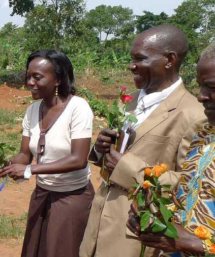 Uganda-GGn-(28).jpg - Judith Nassali, Director of Global Women?s Organization for Total Knowledge in Uganda; and Henry Matovu, National Director of the Transcendental Meditation Programme for Uganda, receive flowers from the students.
